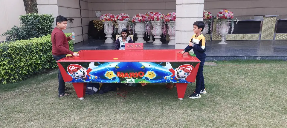 Kids enjoying an air hockey table during a Lucknow celebration