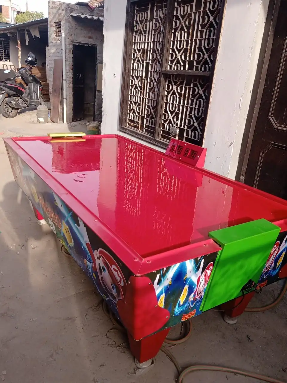 Side view of a red air hockey table ready for event rental in Lucknow