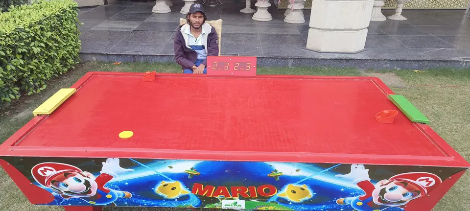 Red air hockey table with digital scoreboard arranged for a Lucknow party