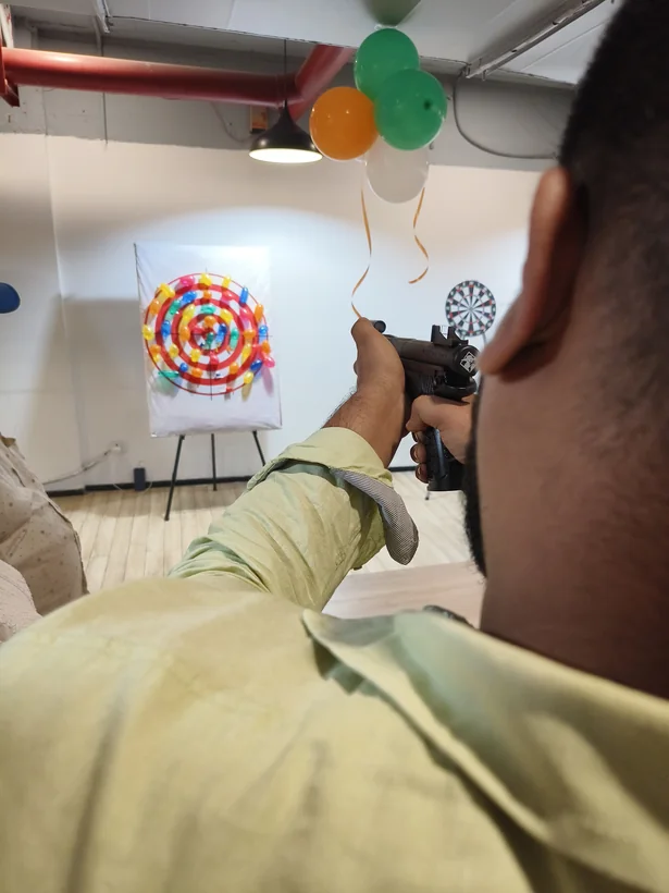 Guest aiming at a balloon shooting target during an event in Lucknow