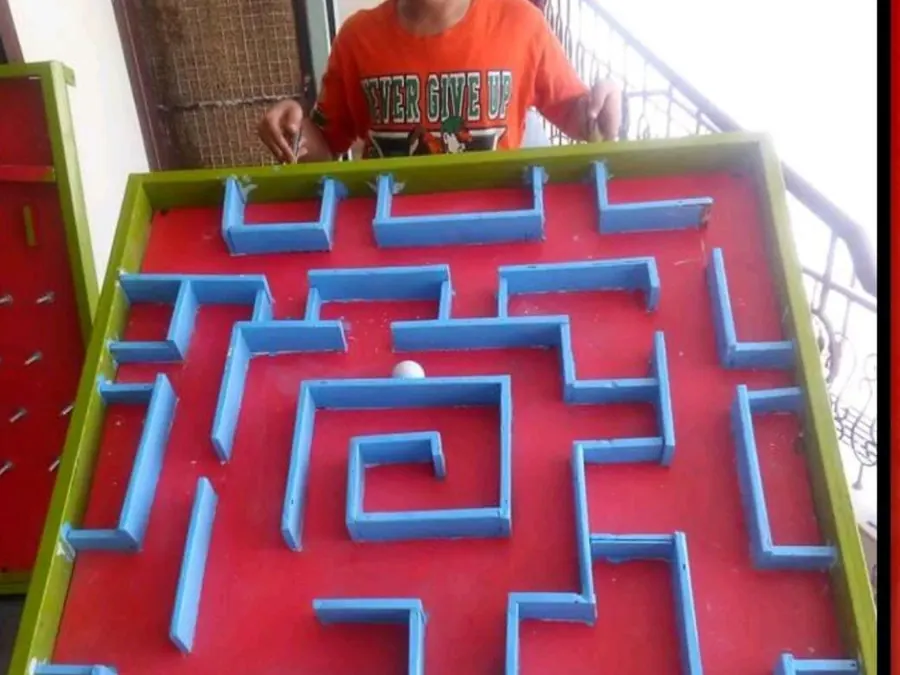 Guest guiding a ball through a large colourful tabletop maze game