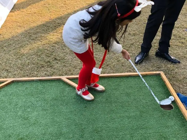 Young guest taking a putt on a portable miniature golf lane