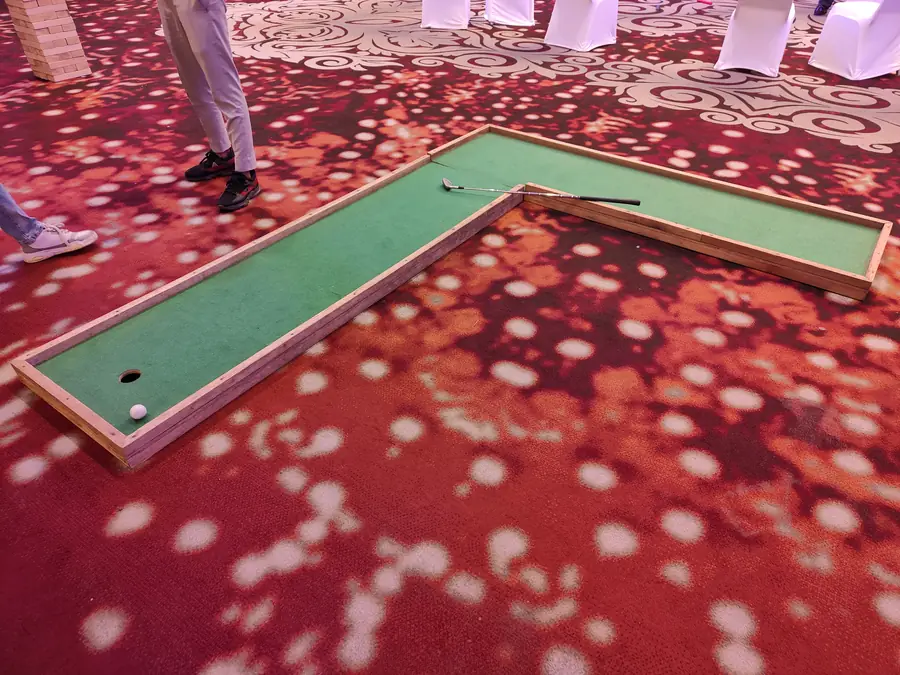 Portable L-shaped mini golf lane installed inside an event venue